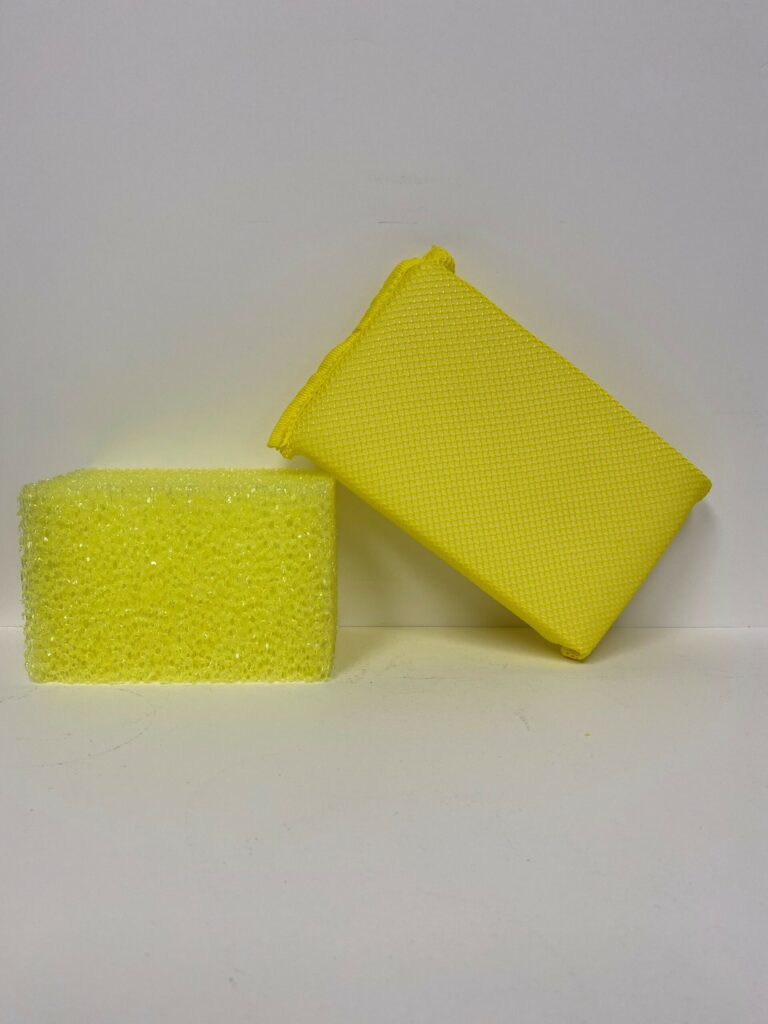Two yellow cleaning sponges, one upright and one lying down.