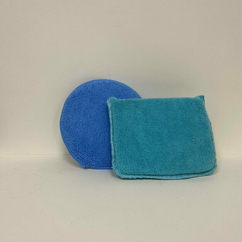 Blue round sponge and square scrubber on white background.
