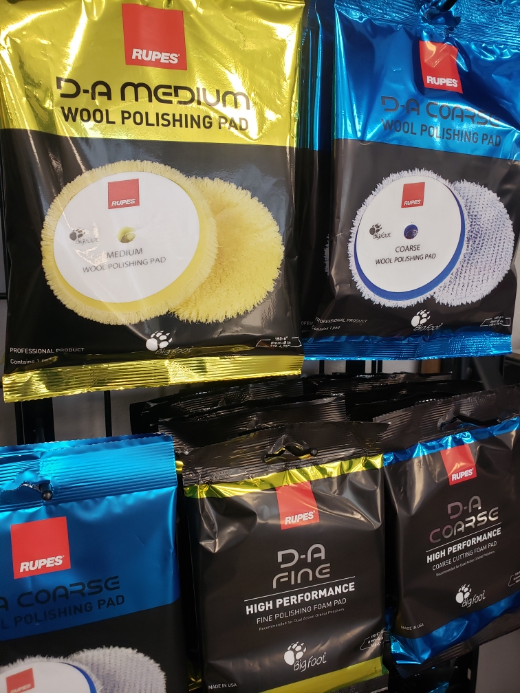 Various car care polishing pads and cloths displayed in packaging.