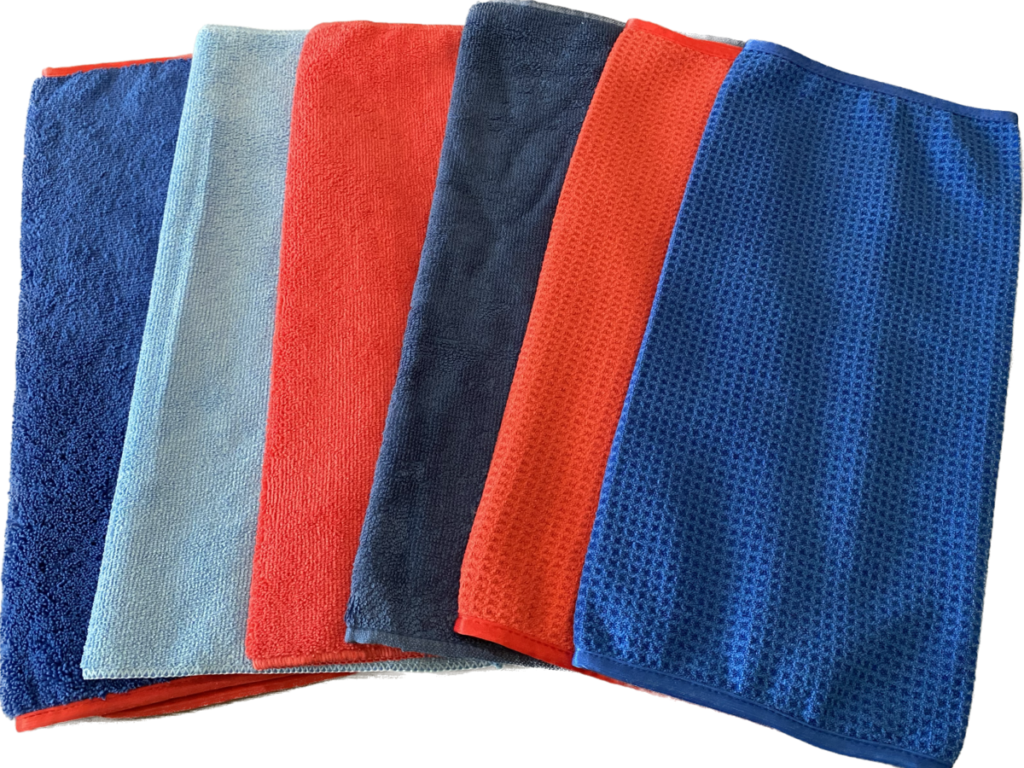 A stack of colorful microfiber cleaning cloths in red, blue, and gray.