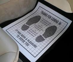 A floor mat with shoe prints and a caution message about COVID-19.