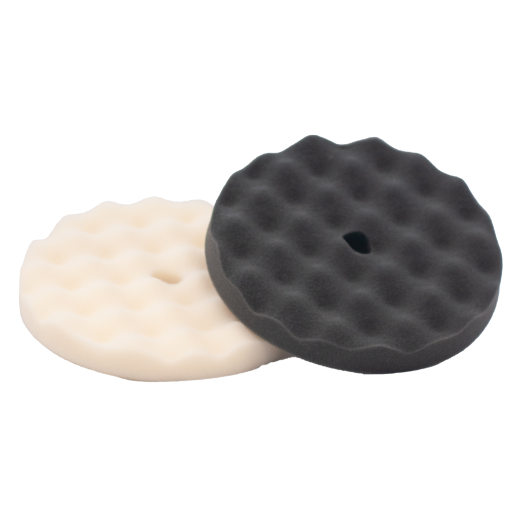 Two round foam polishing pads, one black and one white.
