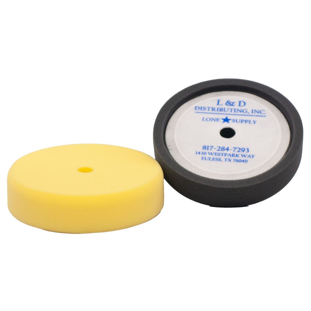 Two polishing pads, one yellow and one black with a label.
