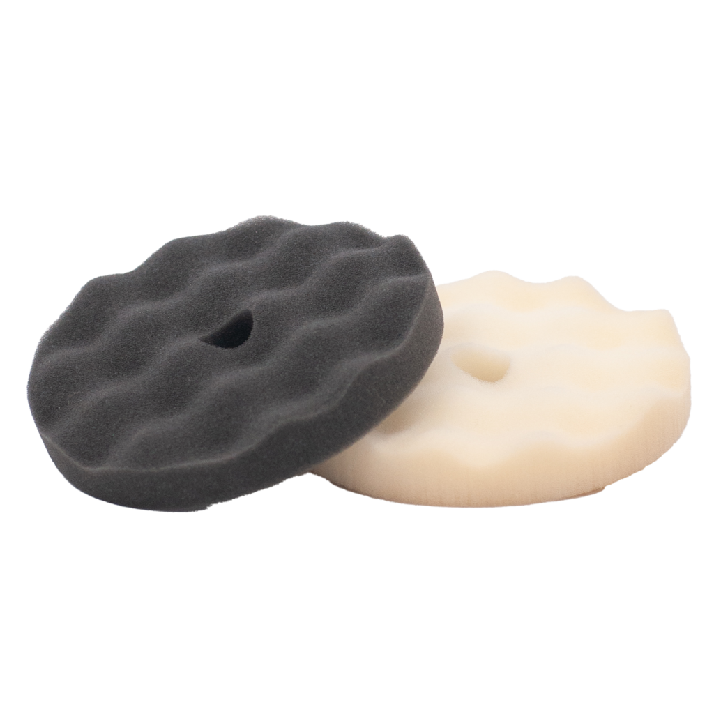 Two textured polishing pads, one black and one white, with wavy surfaces.