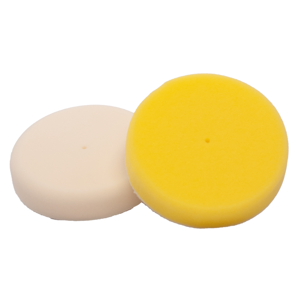 Two round polishing pads, one yellow and one white.